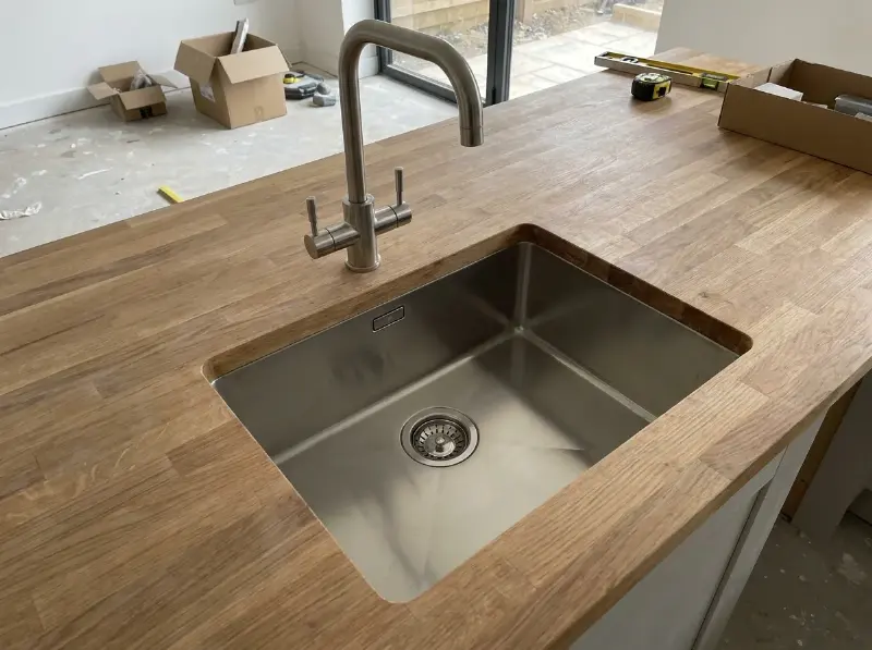 Roestvrijstalen spoelbak met een hoge mengkraan in een werkblad geplaatst
